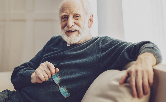 Man sitting on a chair holding glasses